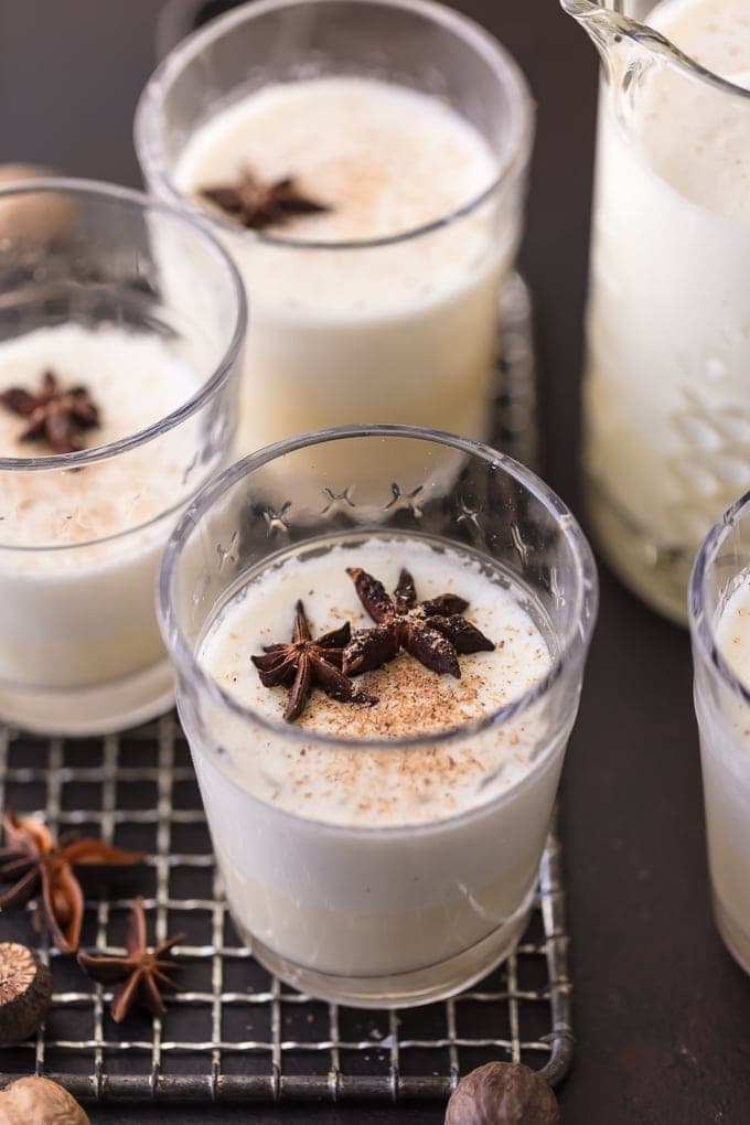 3 glasses of homemade eggnog garnished with freshly grated nutmeg and star anise pods