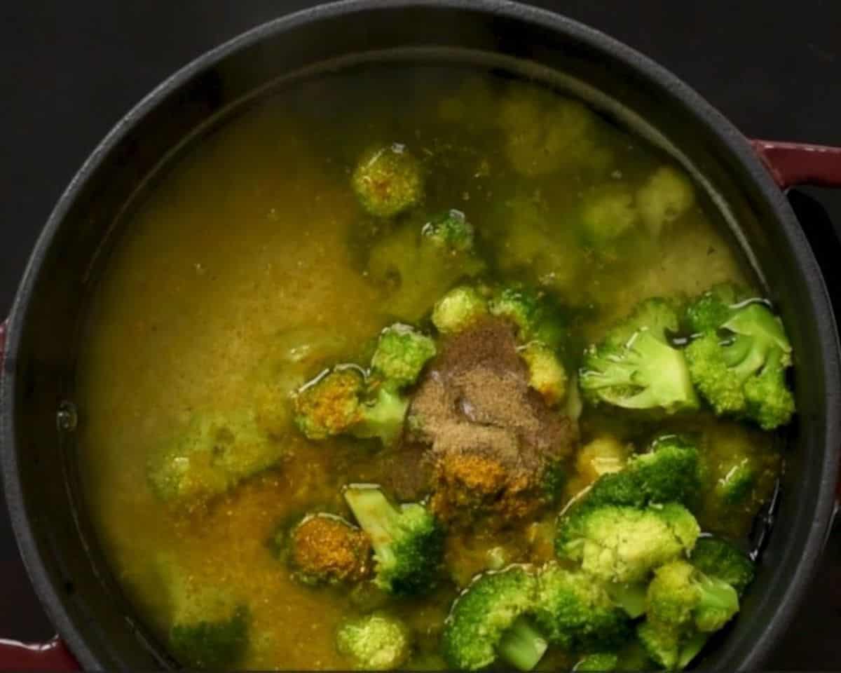 Cooking the broccoli and rice with spices and chicken stock.