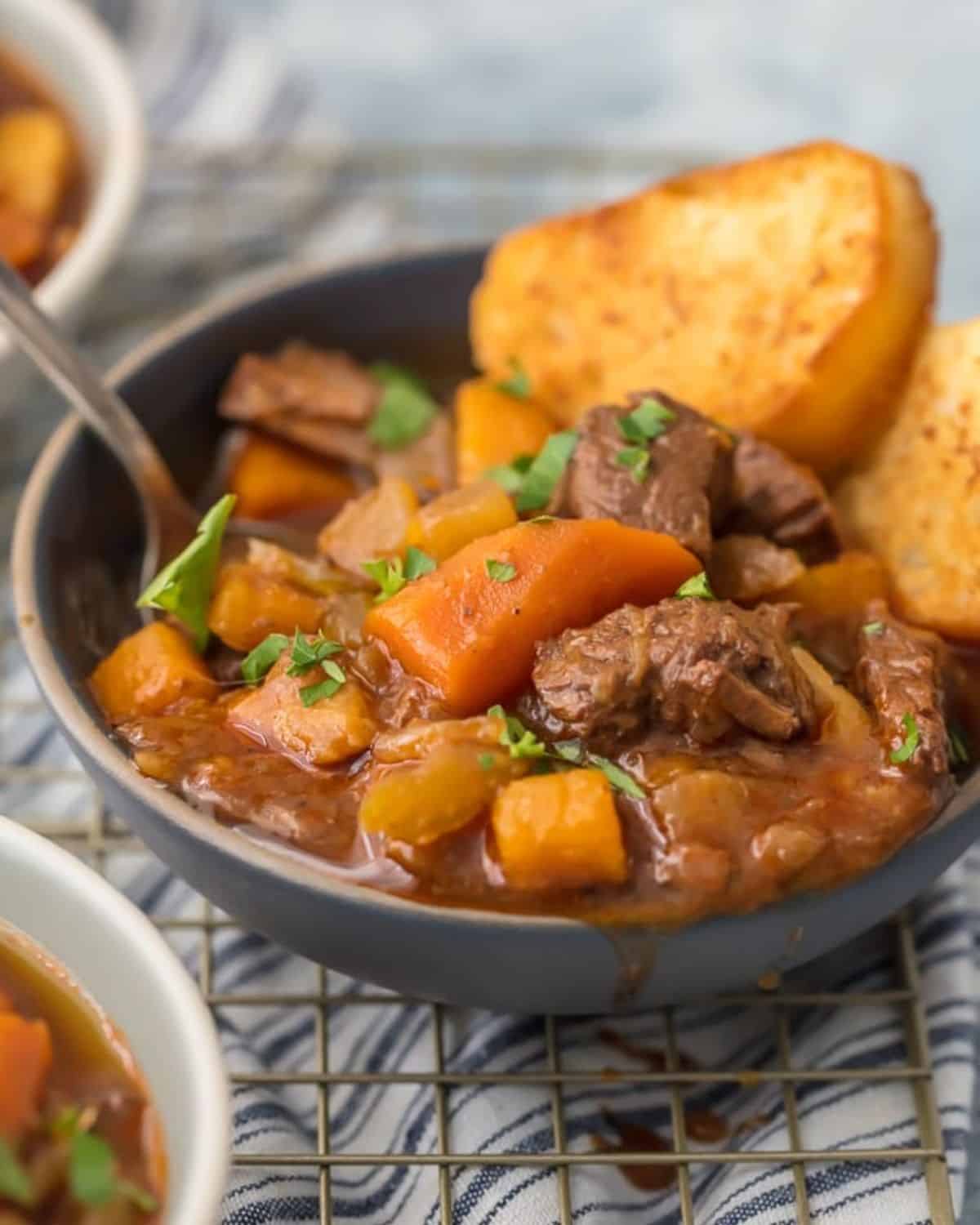 Instant Pot beef stew in a bowl with 2 slices of toasted bread.