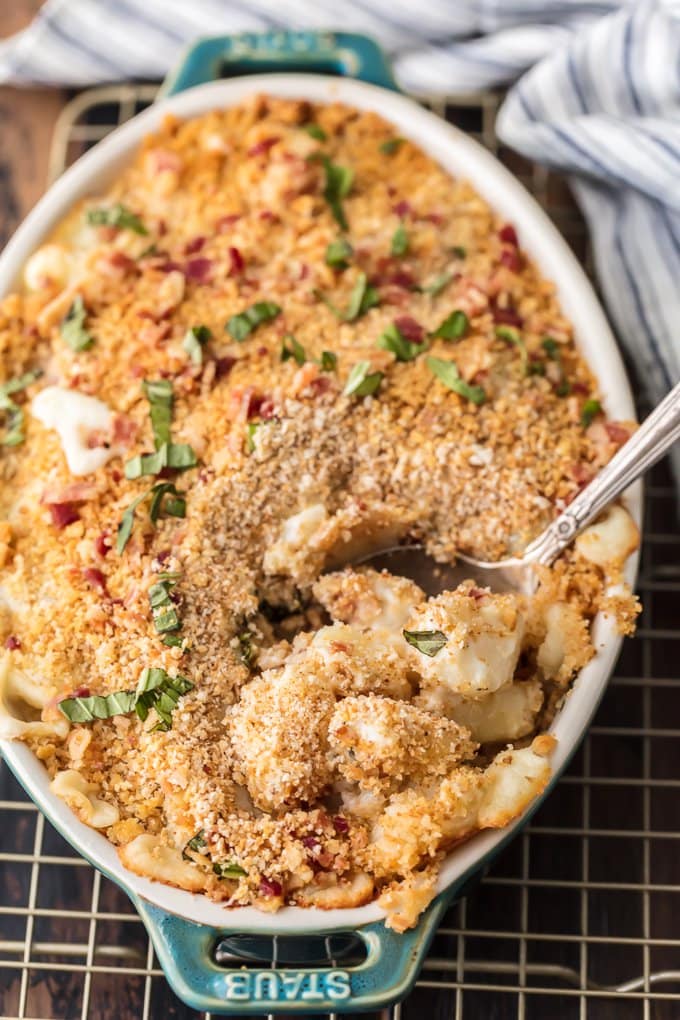 a spoon in a baking dish filled with Cheesy Bacon Gnocchi Bake