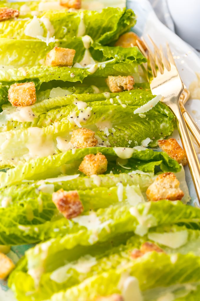 close view of dressing, croutons, and cheese on lettuce