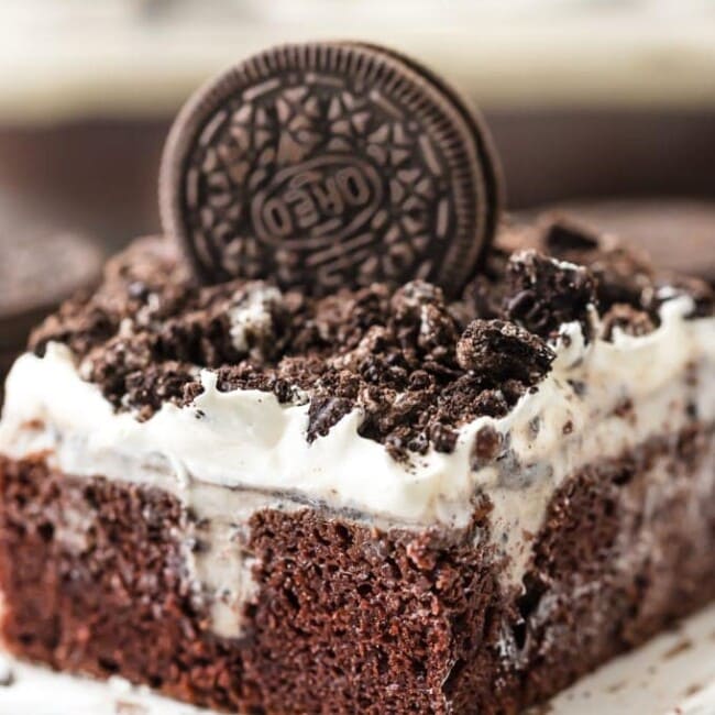 creamy oreo poke cake piece on a white board