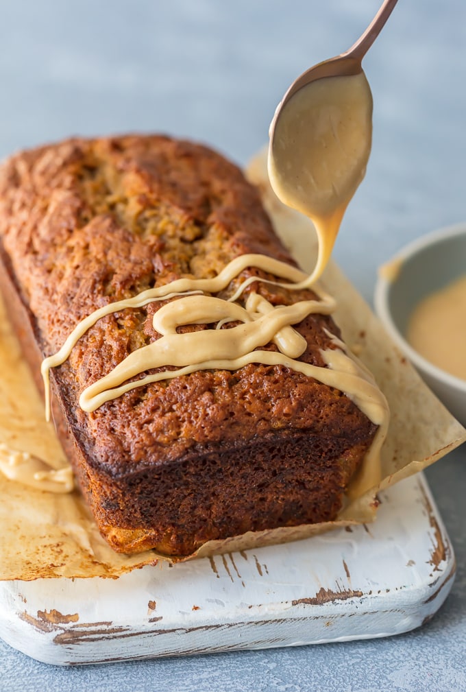 Peanut butter glaze being drizzled onto loaf of bread