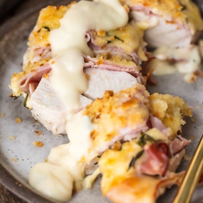 Easy Chicken Cordon Bleu with the BEST Chicken Cordon Bleu Sauce EVER is my favorite recipe for entertaining a crowd. Instead of spending time rolling and stuffing, this Chicken Cordon Bleu Recipe has layers of chicken, ham, cheese, bread crumbs, and is delicious white wine dijon sauce. Get ready to learn how to make Chicken Cordon Bleu as well as what to SERVE with Chicken Cordon Bleu. Best easy chicken recipe ever.