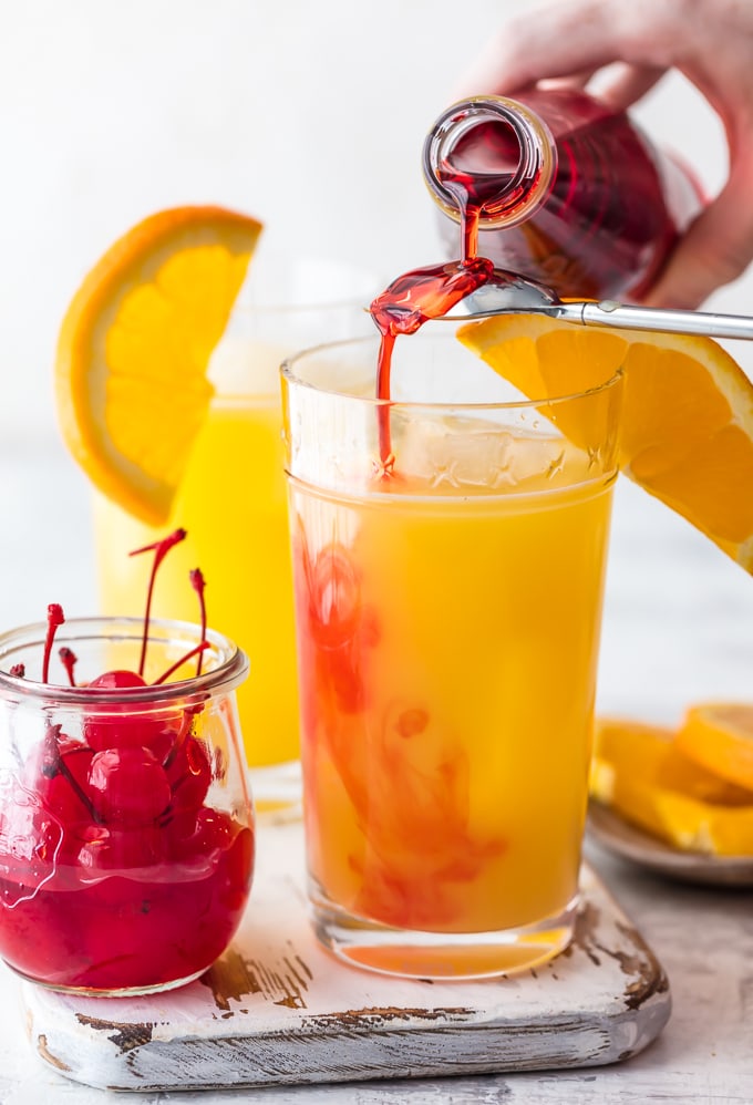 This GAME DAY TEQUILA SUNRISE is tailor made for tailgating! Made with Orange Juice, Grenadine, Tequila, and Beer, this fun cocktail is loved by all and an awesome way to start the day cheering for your favorite team. The ultimate brunch cocktail!