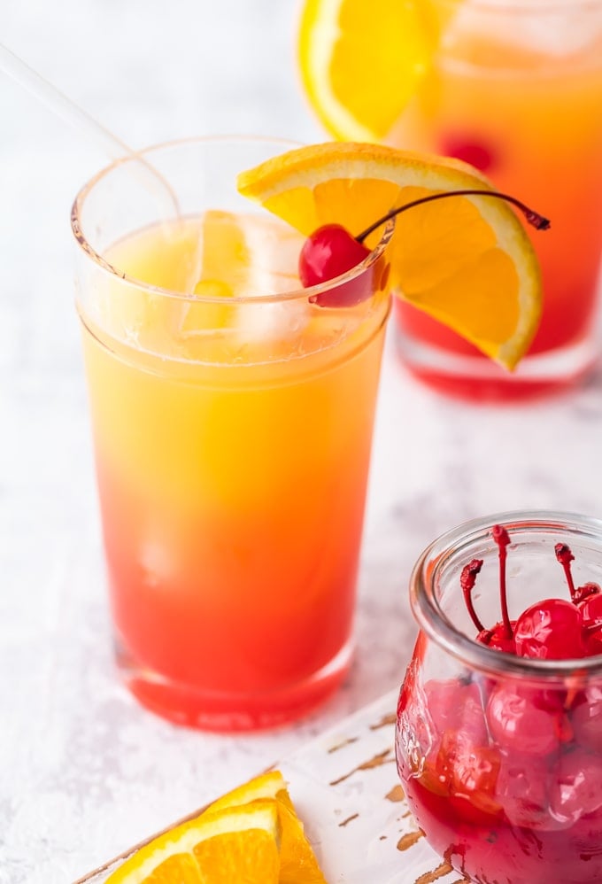 cocktail garnished with orange and cherry