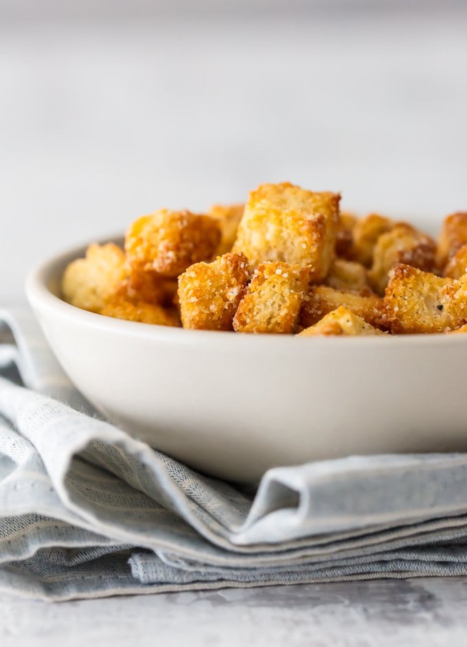 Golden brown baked homemade croutons in a white bowl