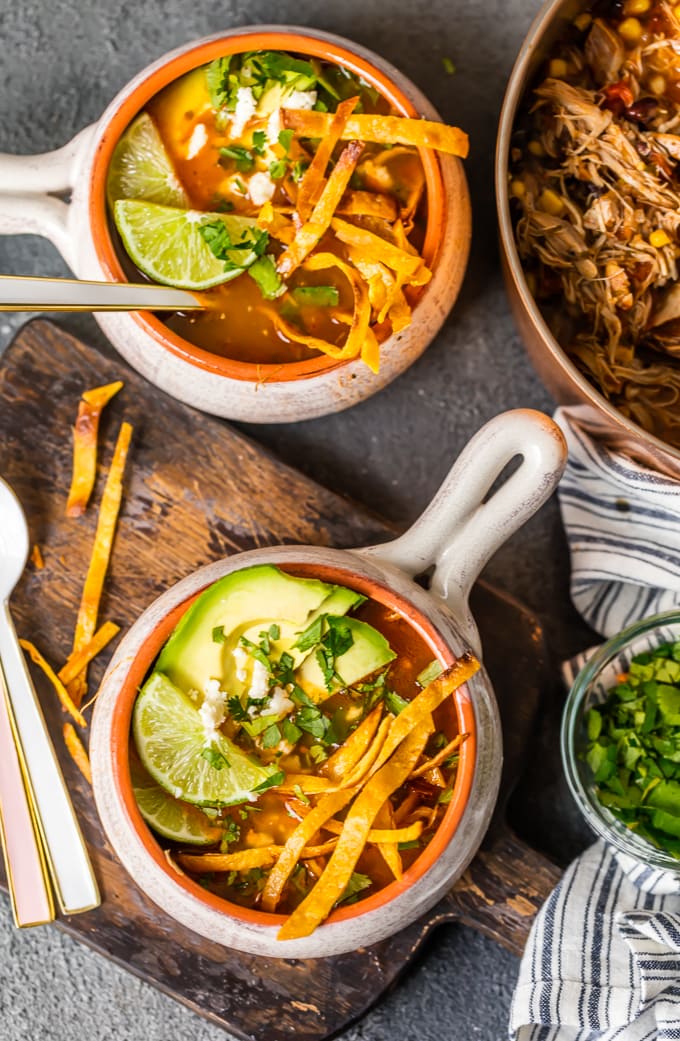 Bowl of chicken tortilla soup topped with corn strips and avocado