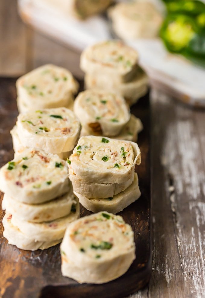 Jalapeno tortilla roll ups stacked on a serving board