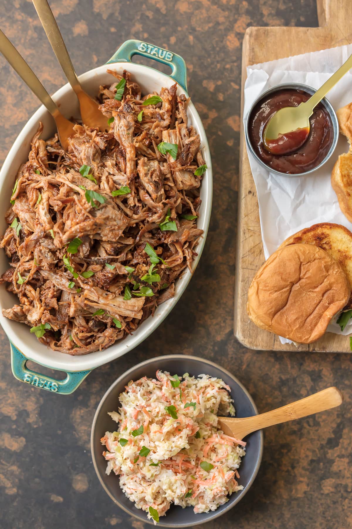 Serving dish filled with BBQ pulled pork, bowl of coleslaw