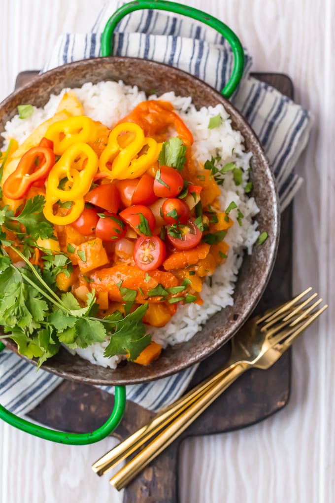 overhead shot of vegetable curry topped with tomatoes and cilantro