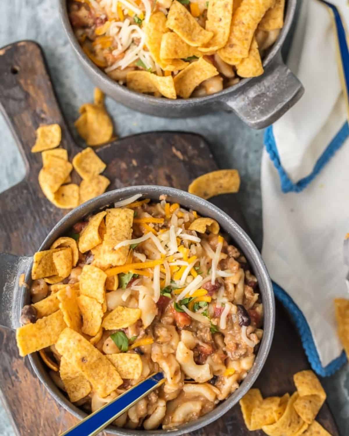 Instant Pot Chili Mac will be your new go-to favorite comfort food! This Chili Mac Recipe is loaded with beef, cheese, beans, tomatoes, and more, kids and adults alike will be back for seconds. We love to top ours with fritos, sour cream, and more cheese. There's nothing like a bowl of Chili Mac and Cheese on a chilly night. Two bowls of Instant Pot chili mac.