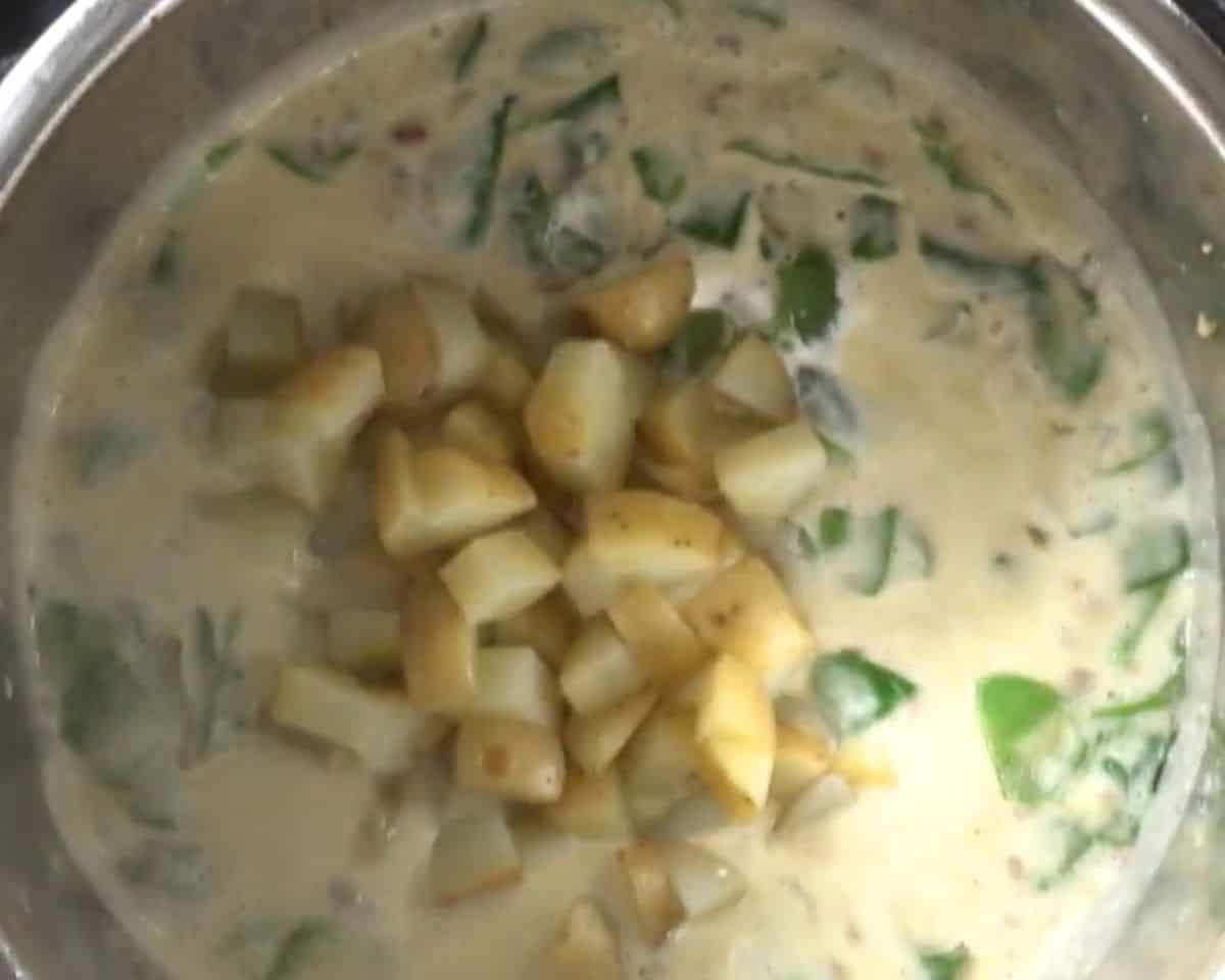 Adding the potatoes, cream, spinach, and remaining ingredients to the pot.