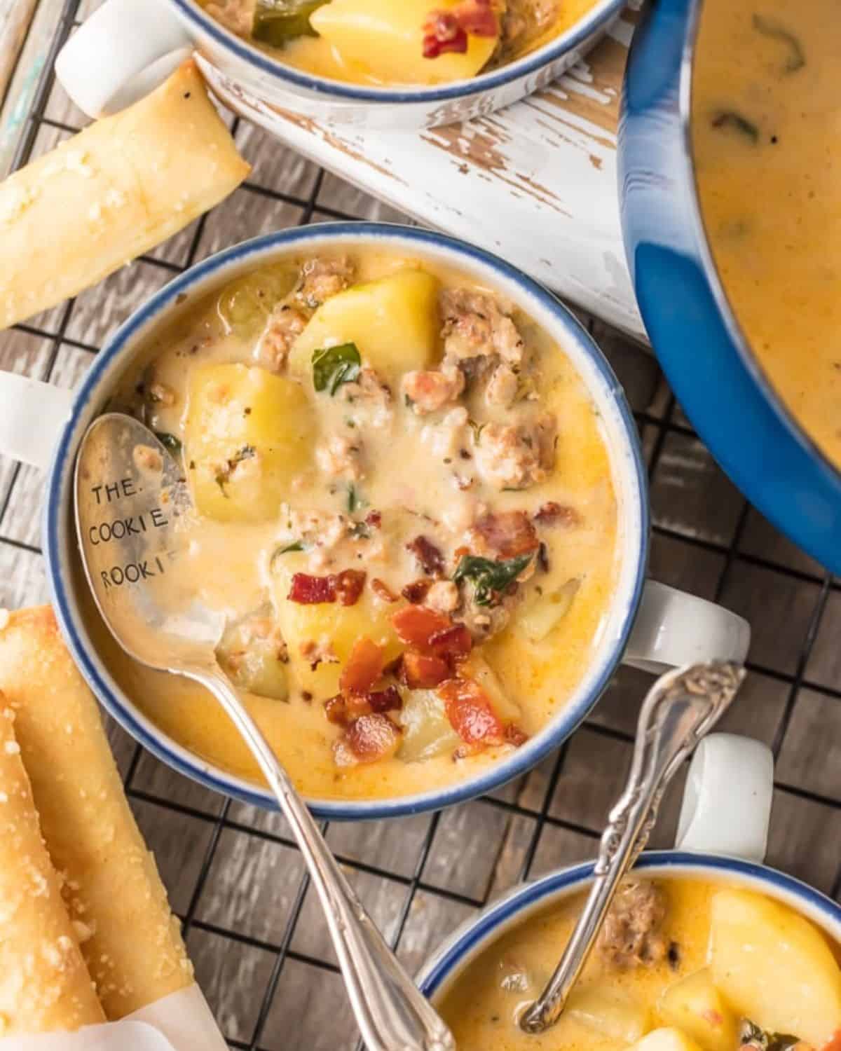 Instant Pot Zuppa Toscana is my new go-to Instant Pot Recipe! Every time we go to Olive Garden I get Zuppa Toscana and I just love that I can make this DELICIOUS copycat recipe at home in under 30 minutes! We first fell in love with this hearty and creamy soup at Olive Garden but I love this quick pressure cooker version even more. This Zuppa Toscana Recipe is loaded with sausage, bacon, potatoes, spinach, and so much flavor. Bowls of Instant Pot Zuppa Toscana soup.