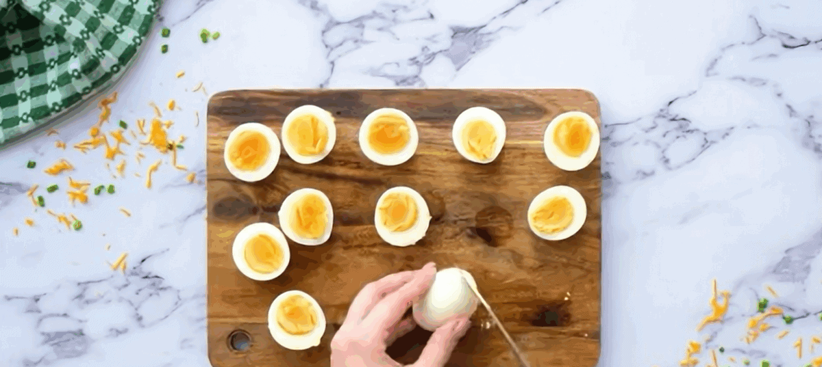 Cutting eggs in half and trimming off the bottom.