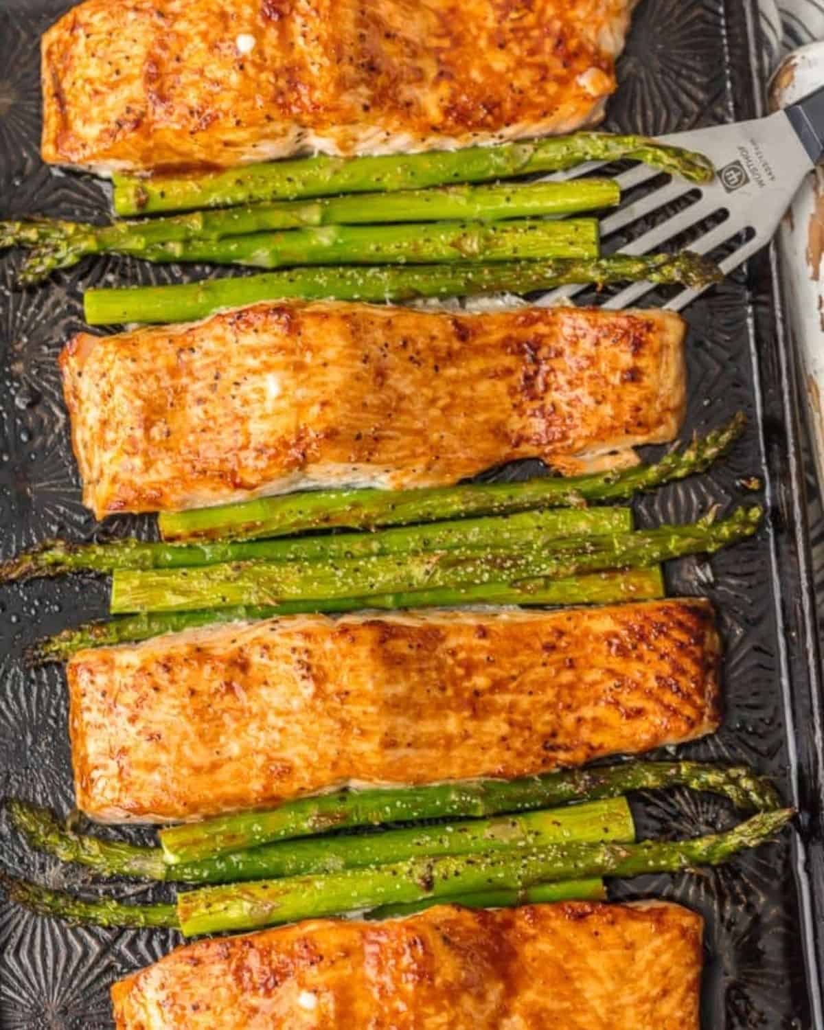 Salmon and Asparagus with Hoisin Sauce is a simple and healthy (yet totally delicious) dinner option. This Baked Salmon and Asparagus recipe has it all! It's an easy seafood recipe made entirely on ONE SHEET PAN, along with a simple hoisin glaze recipe. So much flavor and so little prep/cleanup. So much to love about this sheet pan glazed hoisin salmon! Salmon and asparagus on a baking tray.