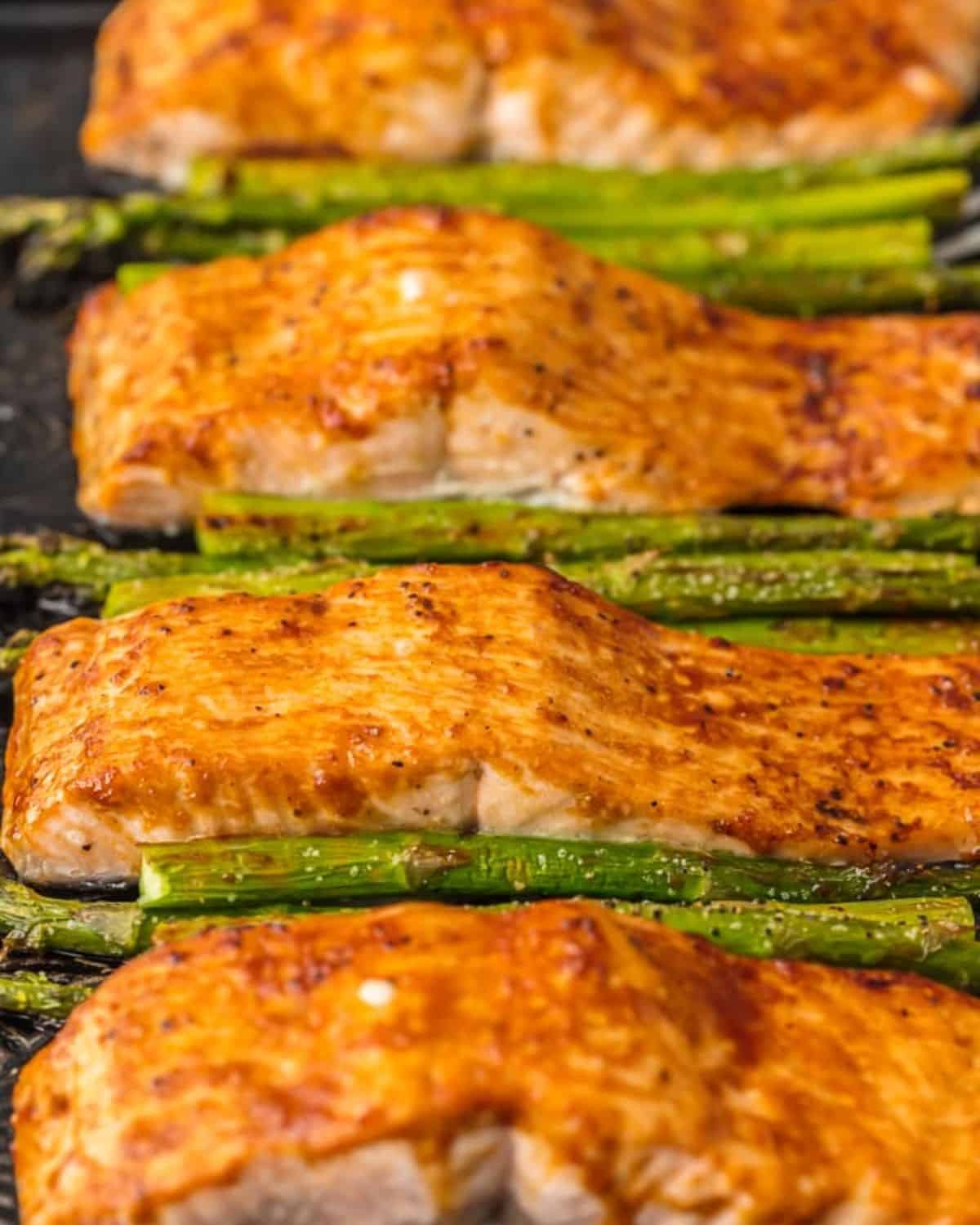 Salmon and Asparagus with Hoisin Sauce is a simple and healthy (yet totally delicious) dinner option. This Baked Salmon and Asparagus recipe has it all! It's an easy seafood recipe made entirely on ONE SHEET PAN, along with a simple hoisin glaze recipe. So much flavor and so little prep/cleanup. So much to love about this sheet pan glazed hoisin salmon! Salmon and asparagus on a sheet pan.