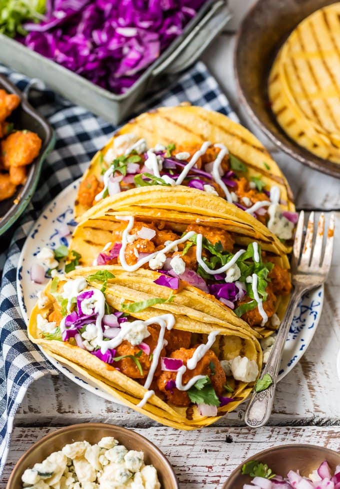 spicy buffalo shrimp tacos on a platter with grilled corn tortillas