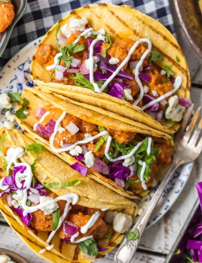 This BUFFALO SHRIMP TACOS RECIPE is tossed in a finger lickin good creamy buffalo sauce and easier than you can even imagine. Perfect for Cinco De Mayo, family night in, or game night with friends! Nothing is better than spicy crispy popcorn shrimp topped with all the fixings and wrapped in a corn tortilla. I'm obsessed.