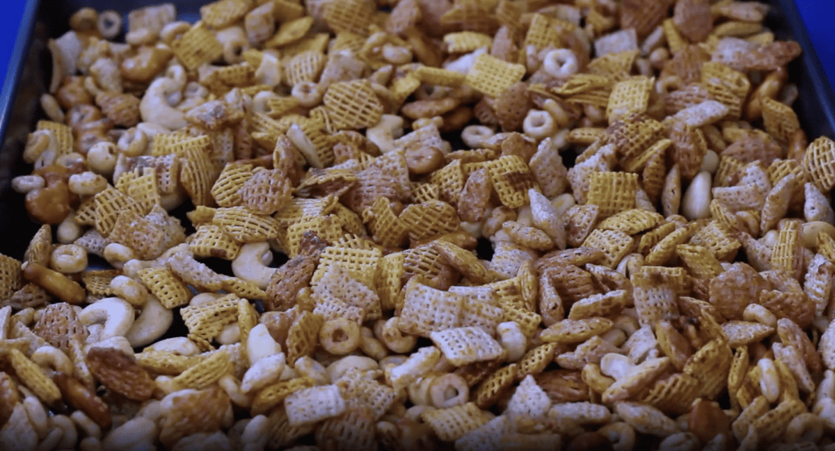 Chex party mix spread out on a baking sheet.