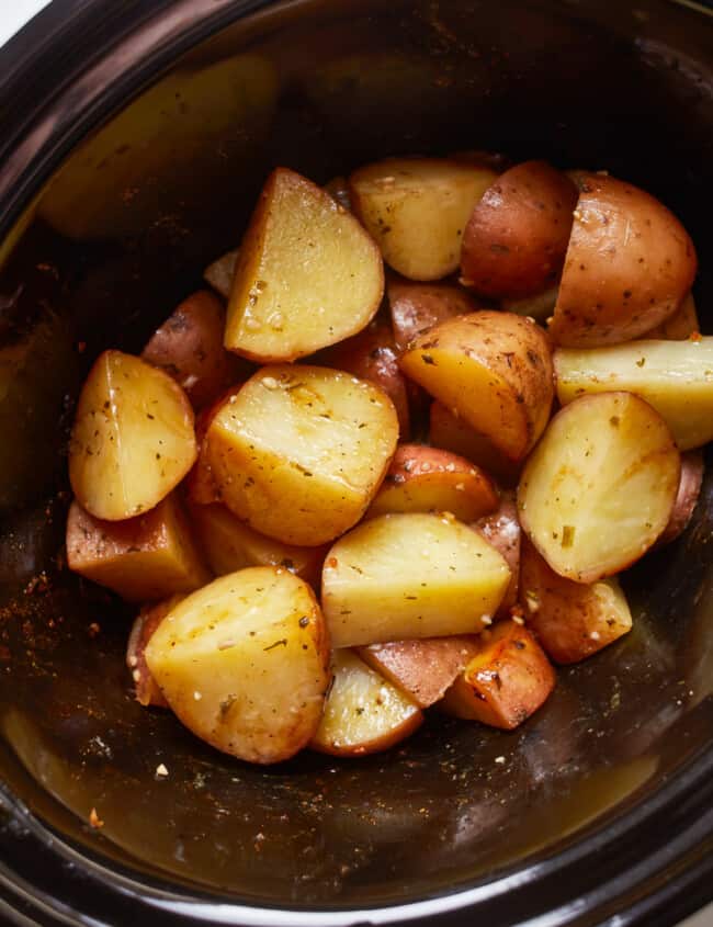 A crockpot filled with potatoes.