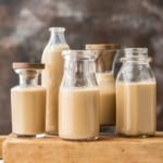 Four jars of homemade Bailey's Irish cream on a wooden cutting board. - 18
