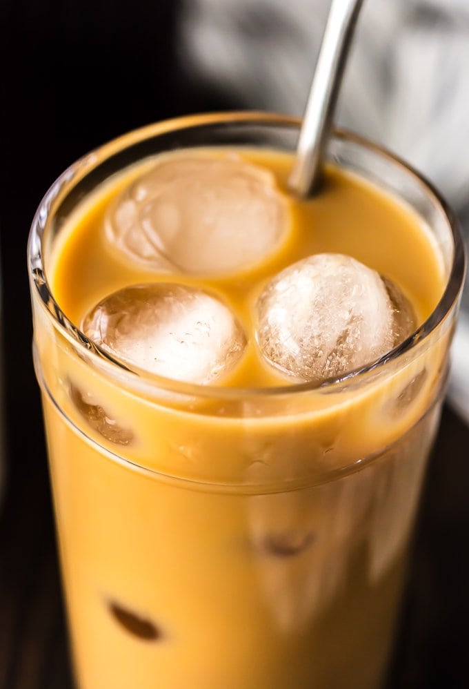 up close picture of iced coffee with cream in a glass