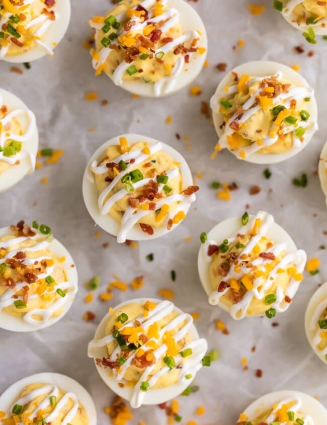 DEVILED EGG RECIPE LOADED just like a Loaded Baked Potato! Smothered in a mixture of cheese, bacon, sour cream, chives, and more! This is the BEST Deviled Eggs Recipe perfect for Easter, Christmas, or any day in between. The ultimate holiday Easy Deviled Eggs.
