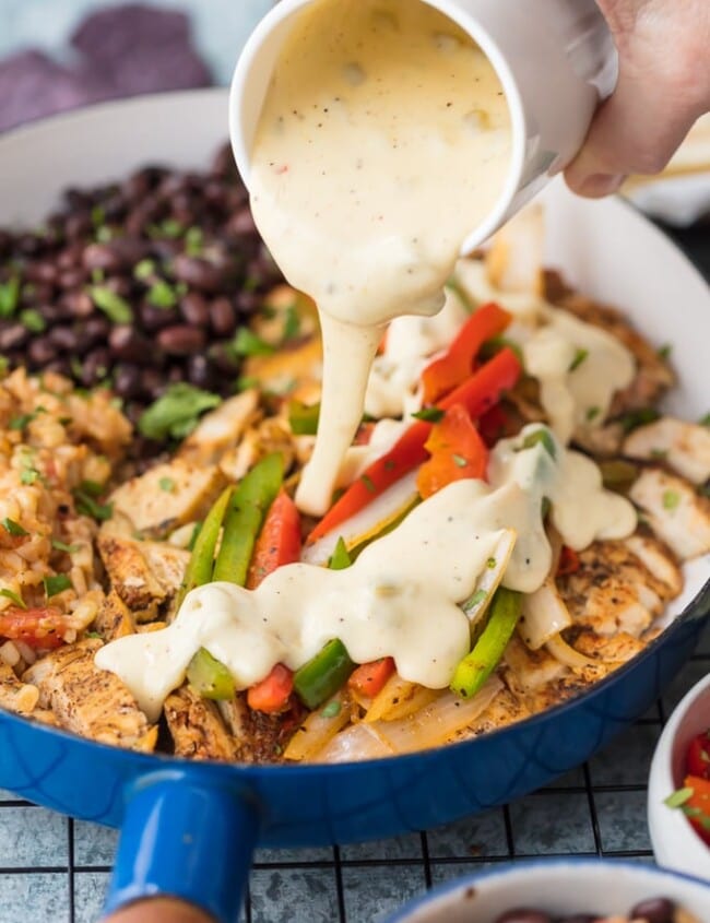 Chicken Fajitas have quickly become a favorite around here, especially this Queso Smothered Chicken Fajita Recipe! Traditional juicy Chicken Fajitas with all the veggies and spice, grilled to perfection, and smothered in cheese dip. This unique twist on a classic Mexican recipe is sure to please one and all and be requested again and again. Better than any Mexican Restaurant meal!