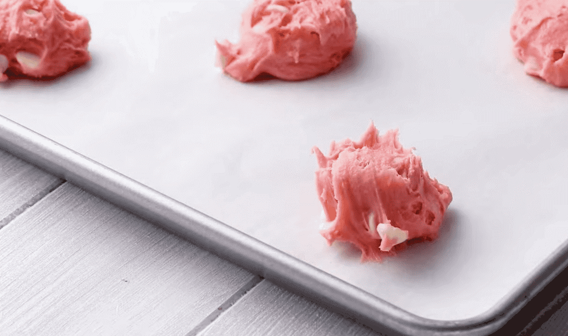 Strawberry cookie dough balls on a baking sheet. 