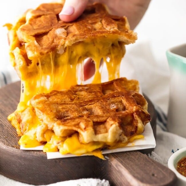 Waffle Sandwich? Yes! This fun and easy Apple Cheddar Waffle Grilled Cheese recipe is so delicious and only has 5 ingredients! The simple flavors of the maple dijon sauce blend perfectly with the creamy cheddar, crisp apples, and sweet waffles.