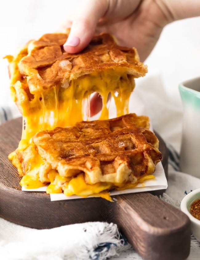 Waffle Sandwich? Yes! This fun and easy Apple Cheddar Waffle Grilled Cheese recipe is so delicious and only has 5 ingredients! The simple flavors of the maple dijon sauce blend perfectly with the creamy cheddar, crisp apples, and sweet waffles.