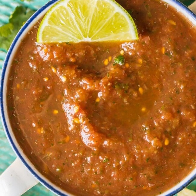 Blender Salsa is the absolute best EASY Homemade Salsa Recipe you'll ever make. Chips and Salsa are a must for Cinco de Mayo and this is our favorite Easy Salsa Recipe. This Homemade Salsa has SO much flavor and has just the perfect amount of heat. Perfect for tailgating!