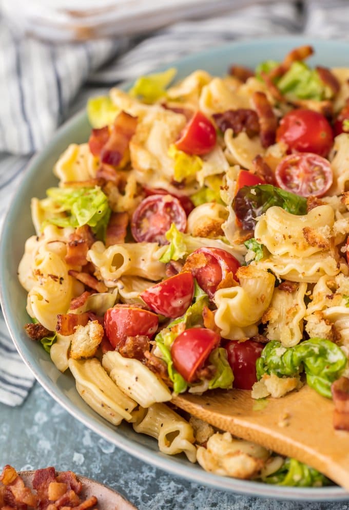 wooden spoon being used to scoop up pasta salad