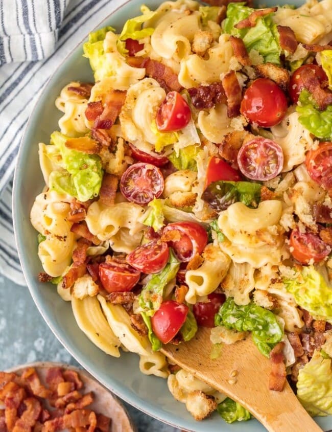 blt pasta salad in a bowl with wooden spoon