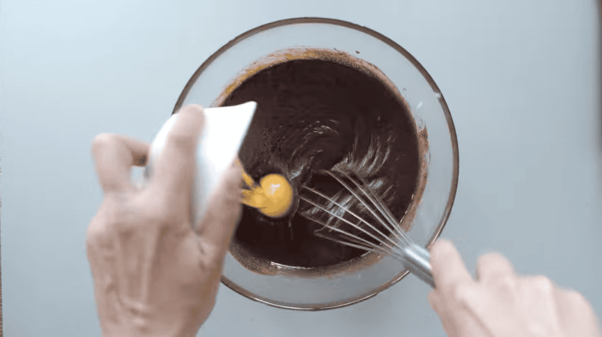 eggs added to melted chocolate with a whisk.