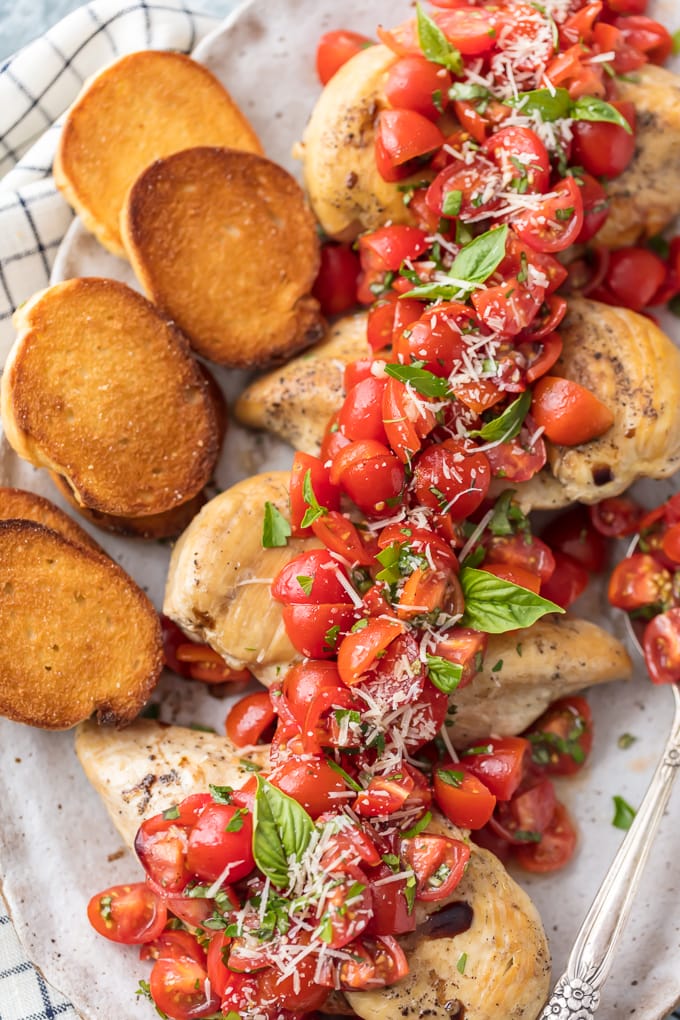plate of chicken, tomato bruschetta, and toasted bread