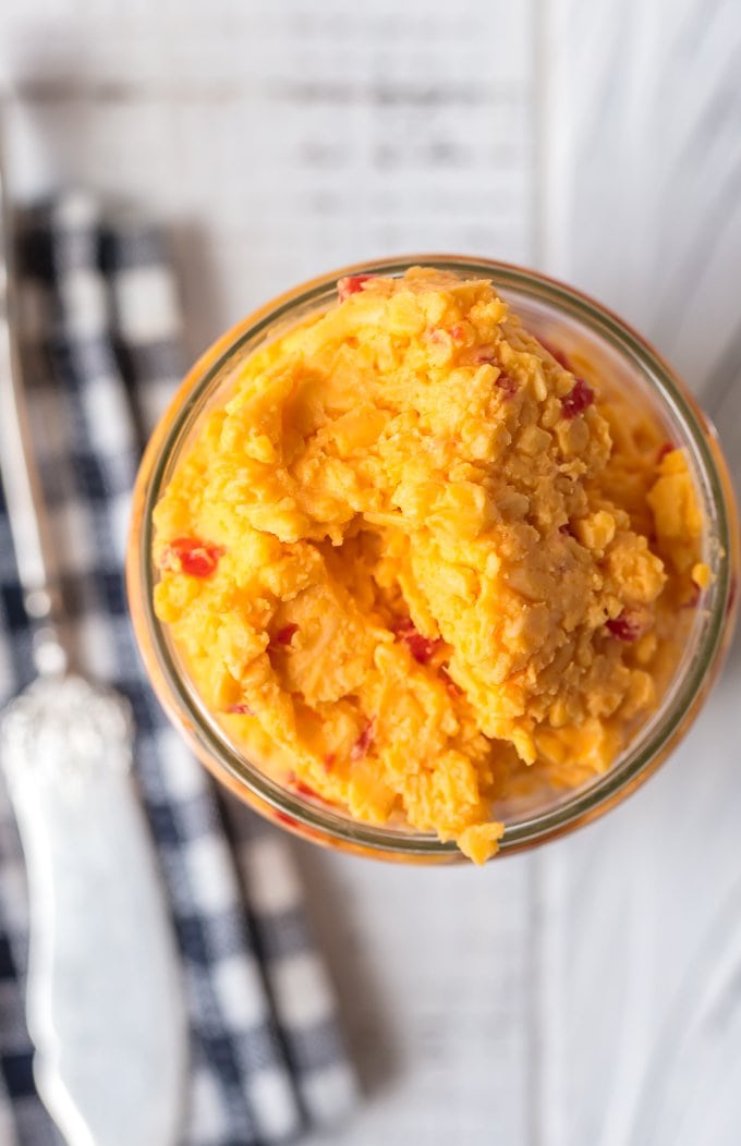 Want to learn How to Make Pimento Cheese? You've come to the right place! This Homemade Pimento Cheese recipe is bold and full of flavor. The classic Southern spread is perfect to serve at parties, and of course it makes an amazing Pimento Cheese Sandwich. With tasty Colby cheese and sweet Pimento peppers, this is the Best Pimento Cheese recipe out there! Homemade Pimento Cheese in a jar, pictured from above