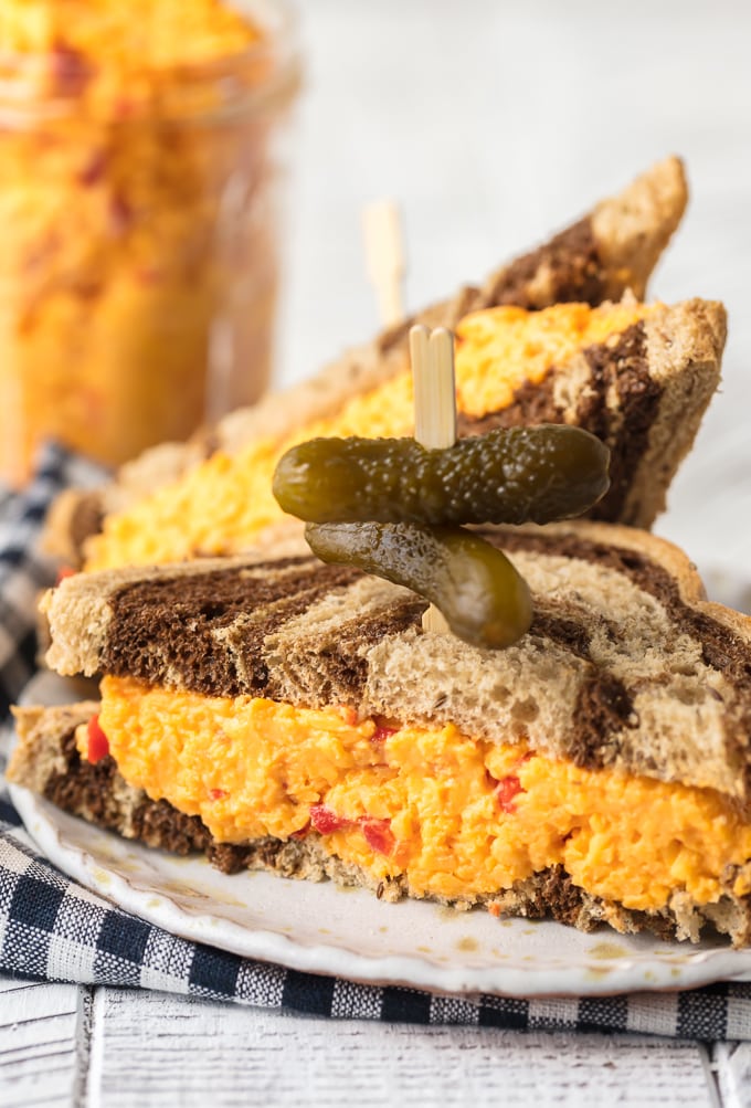 Pimento cheese sandwich on a plate, cut in half.