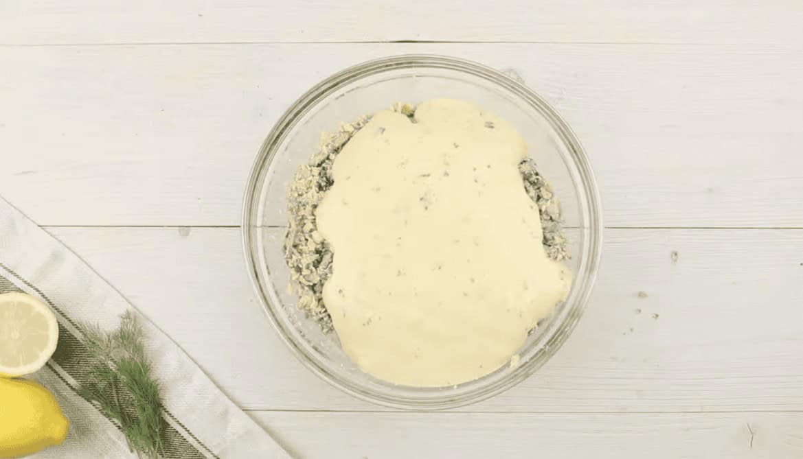 Crab meat and mayonnaise in a glass bowl.