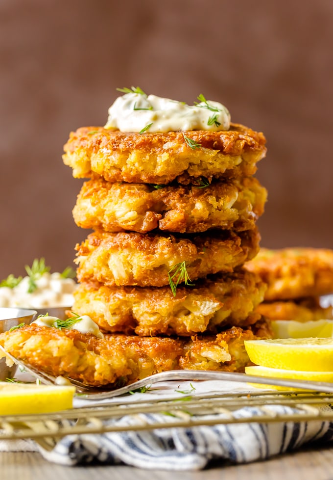 A stack of crab cakes, topped with tartar sauce