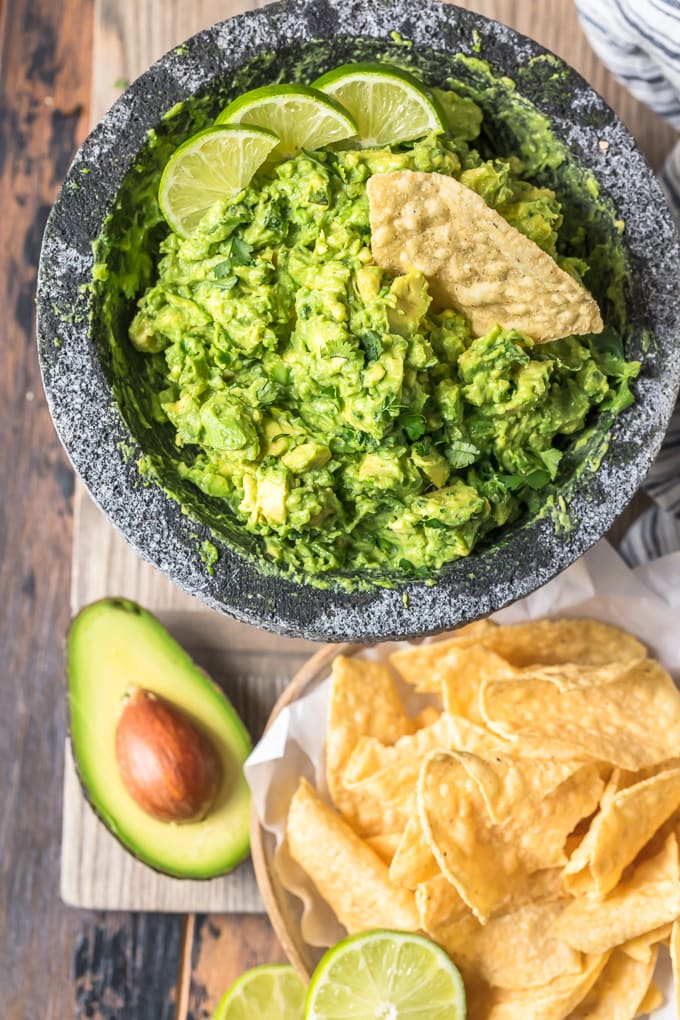 Simple guacamole dip next to a basket of tortilla chips