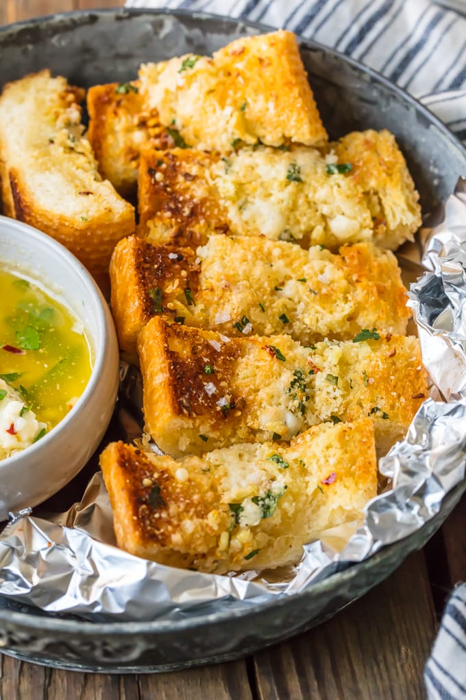 Homemade Garlic Bread is the absolute BEST Garlic Bread Recipe we have ever tried! If you want to learn How to Make Garlic Bread where the butter melts deep into the bread, creating the ultimate garlicky, carb filled side dish, you've come to the right place. We bake it, then broil it, to make it crispy on the outside while staying soft and buttery on the inside.