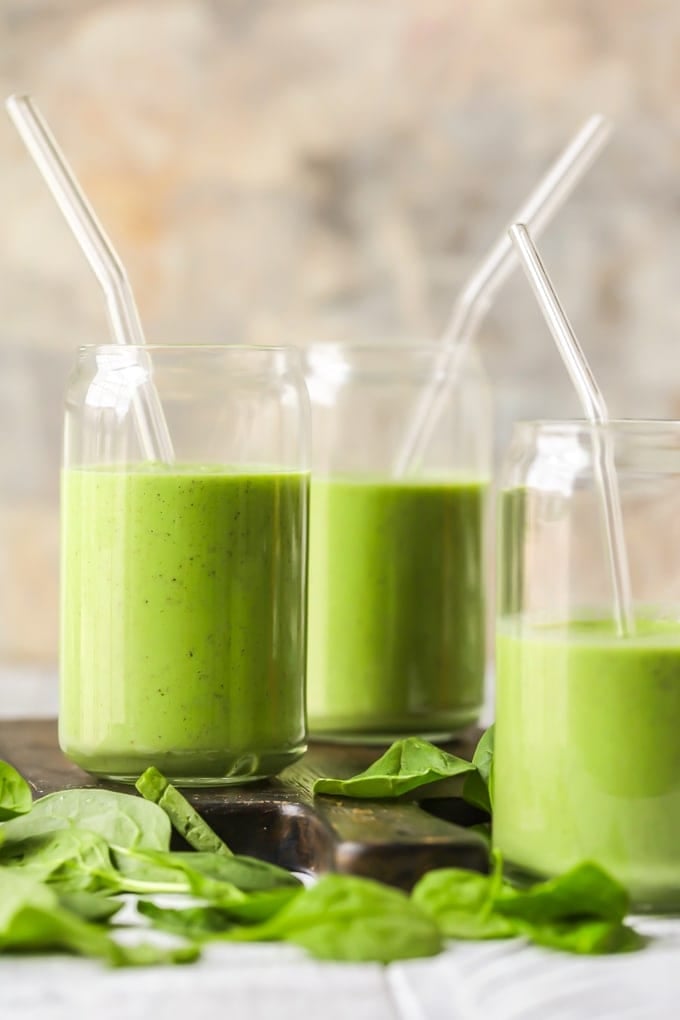 green detox smoothies in glasses on a wooden cutting board