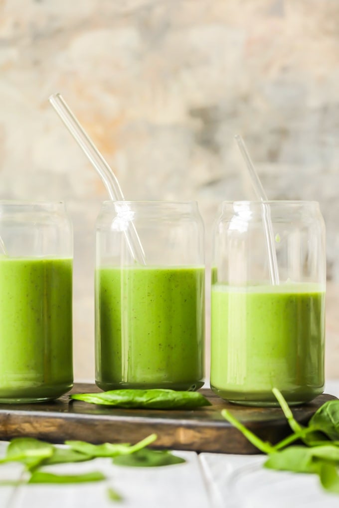 creamy green smoothies on a wooden cutting board