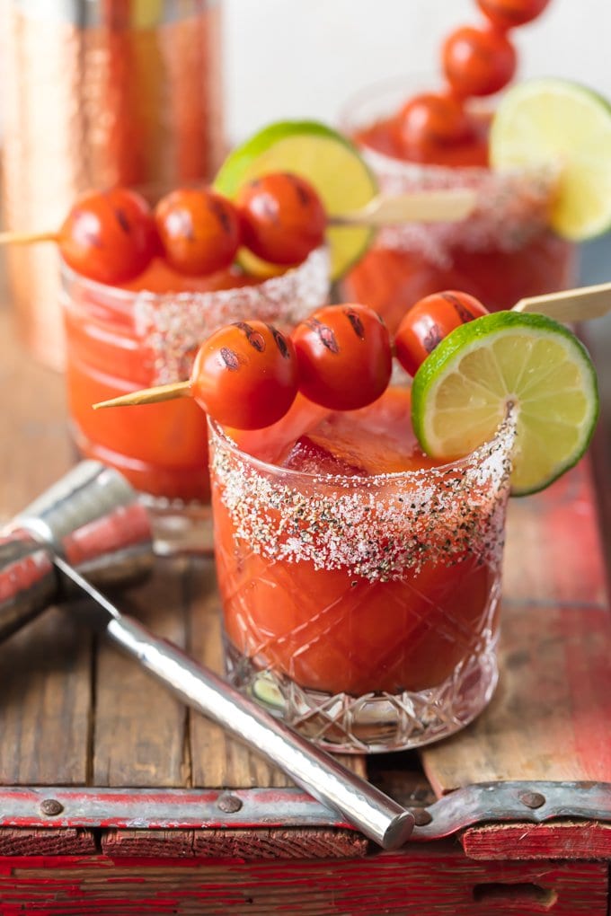 3 tomato margaritas in short glasses, topped with cherry tomatoes