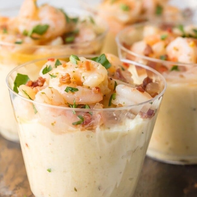 shrimp and grit cups on a wooden cutting board