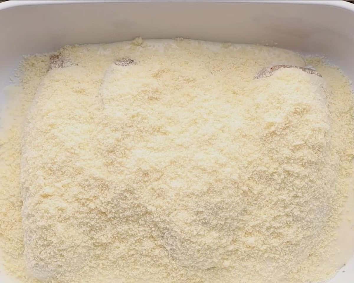Chicken covered with Parmesan cheese.