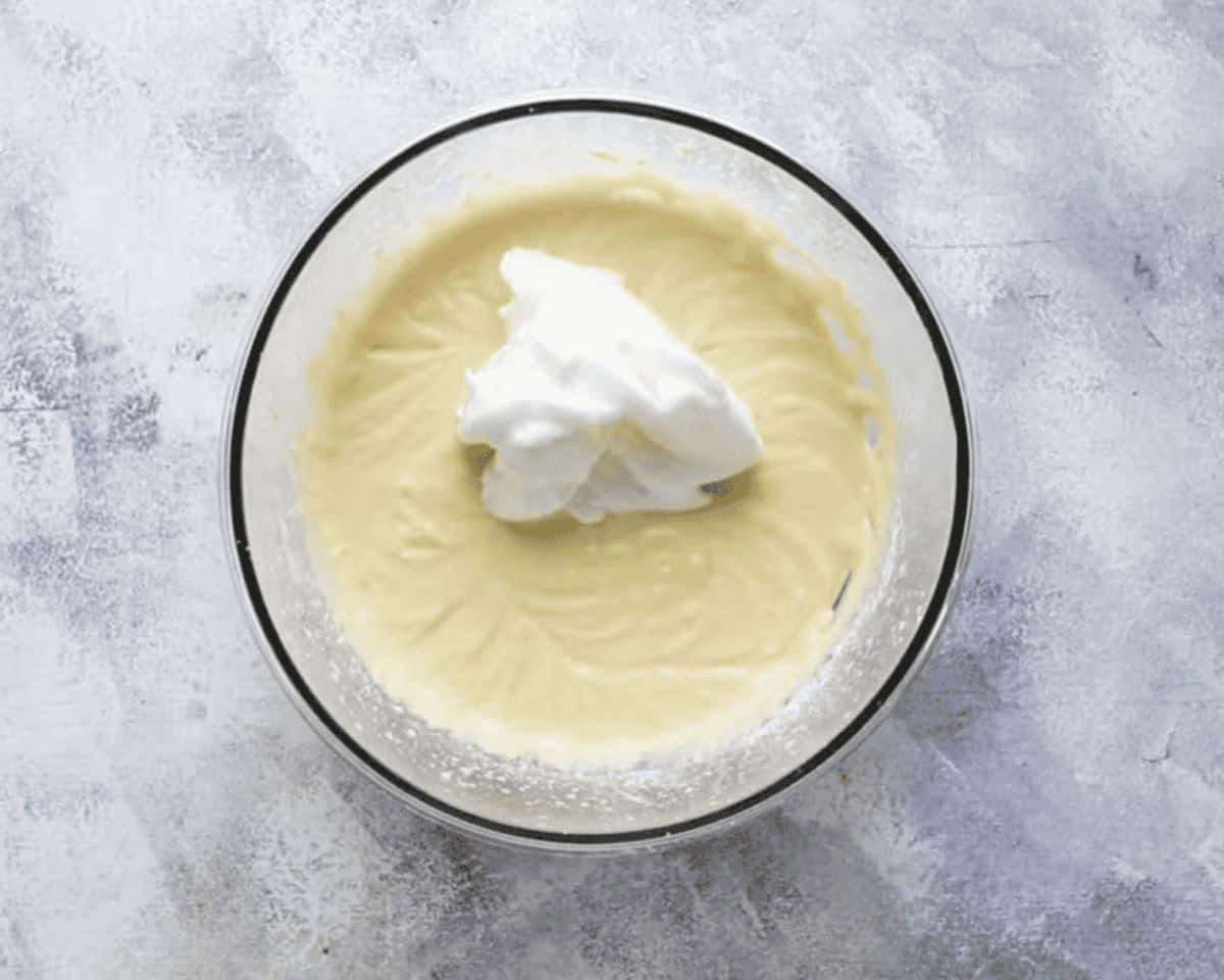 Adding whipped egg whites to the batter.