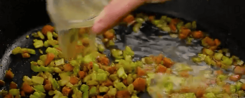 Adding broth the the vegetables for the hand pies.